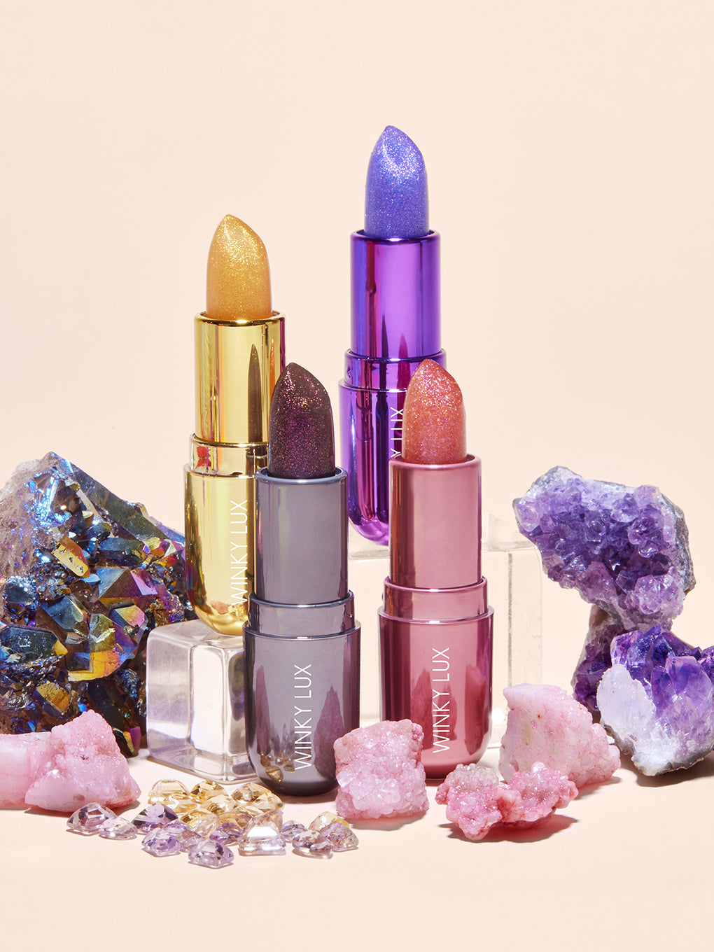 collection of gem stone ph lip balms on props surrounded by stones collection of gem stone ph lip balms on props surrounded by stones