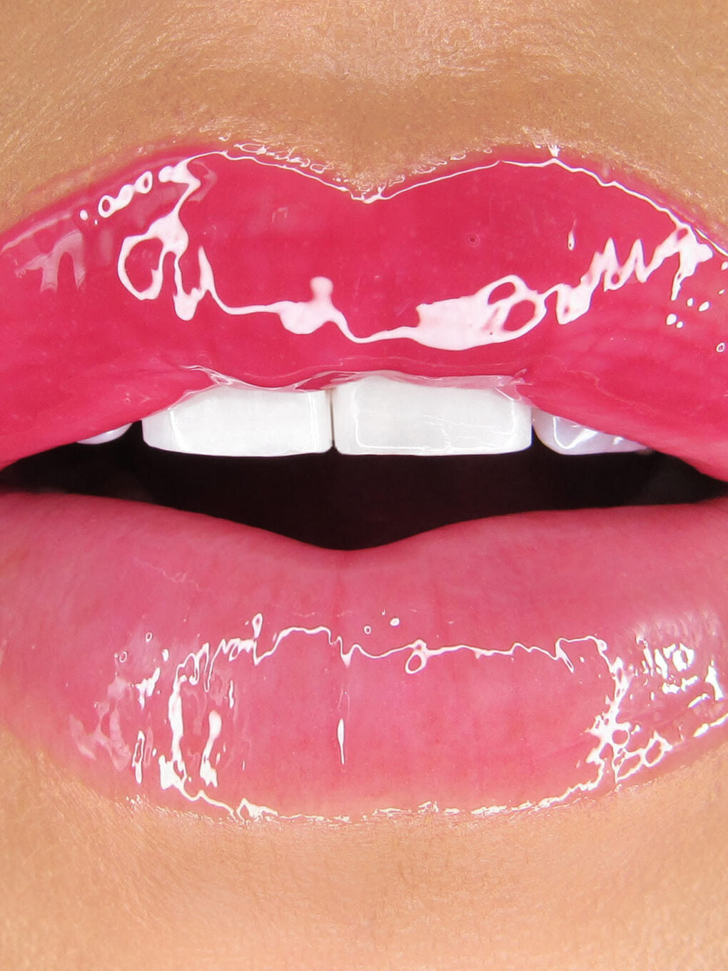 close up of different shades of hydrating lip oils on upper and bottom lip of model