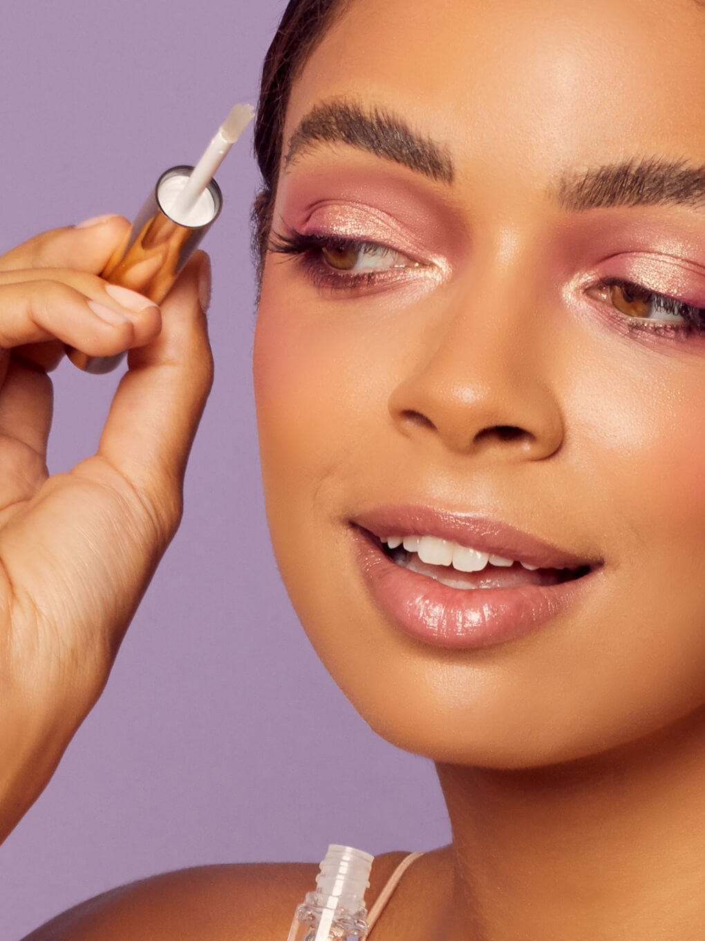 close up of brunette model applying unibrow clear gel