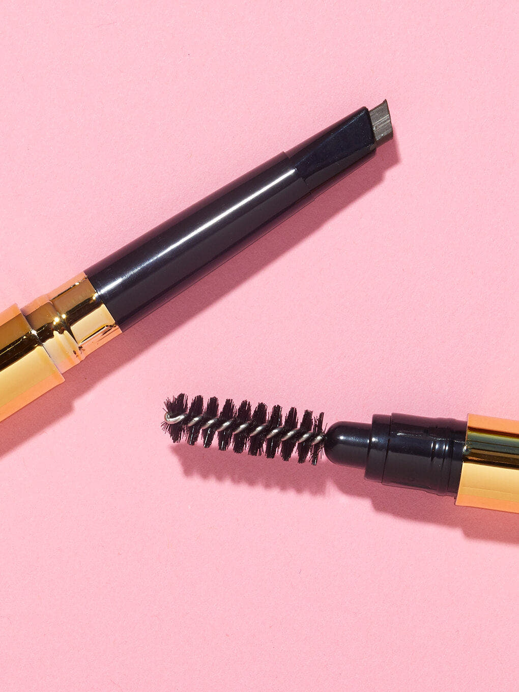 unibrow universal spoolie and pencil flat lay on pink background