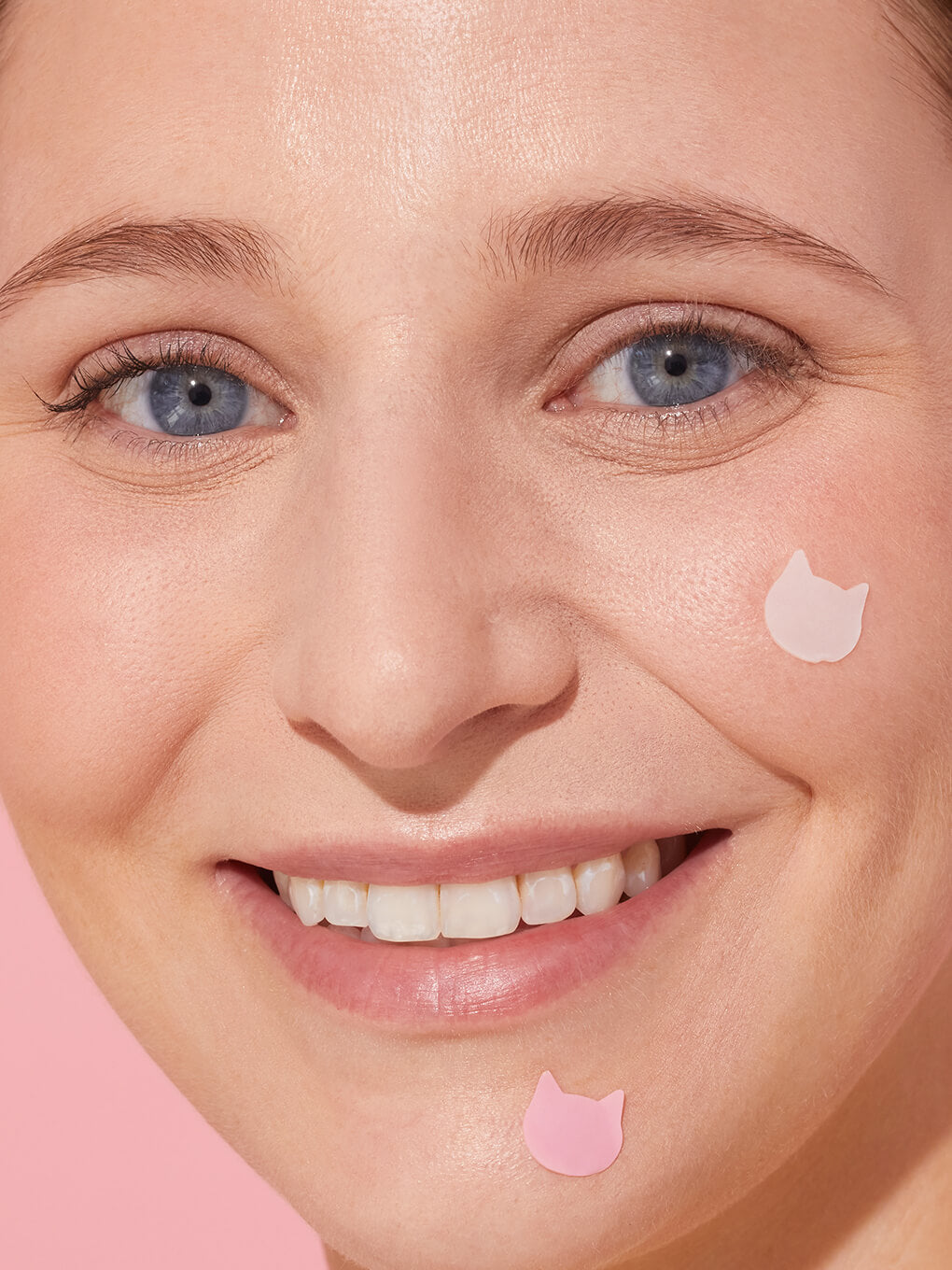 close up of model with cat shaped pimple patch on cheek