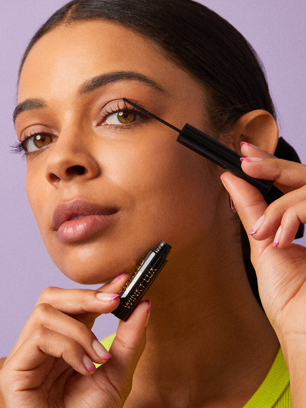 Type A Black -- brunette model applying detail oriented mascara 