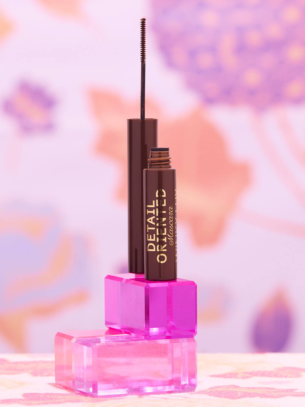 Chocolate -- detail oriented brown mascara cap open standing on blocks showing slender spoolie