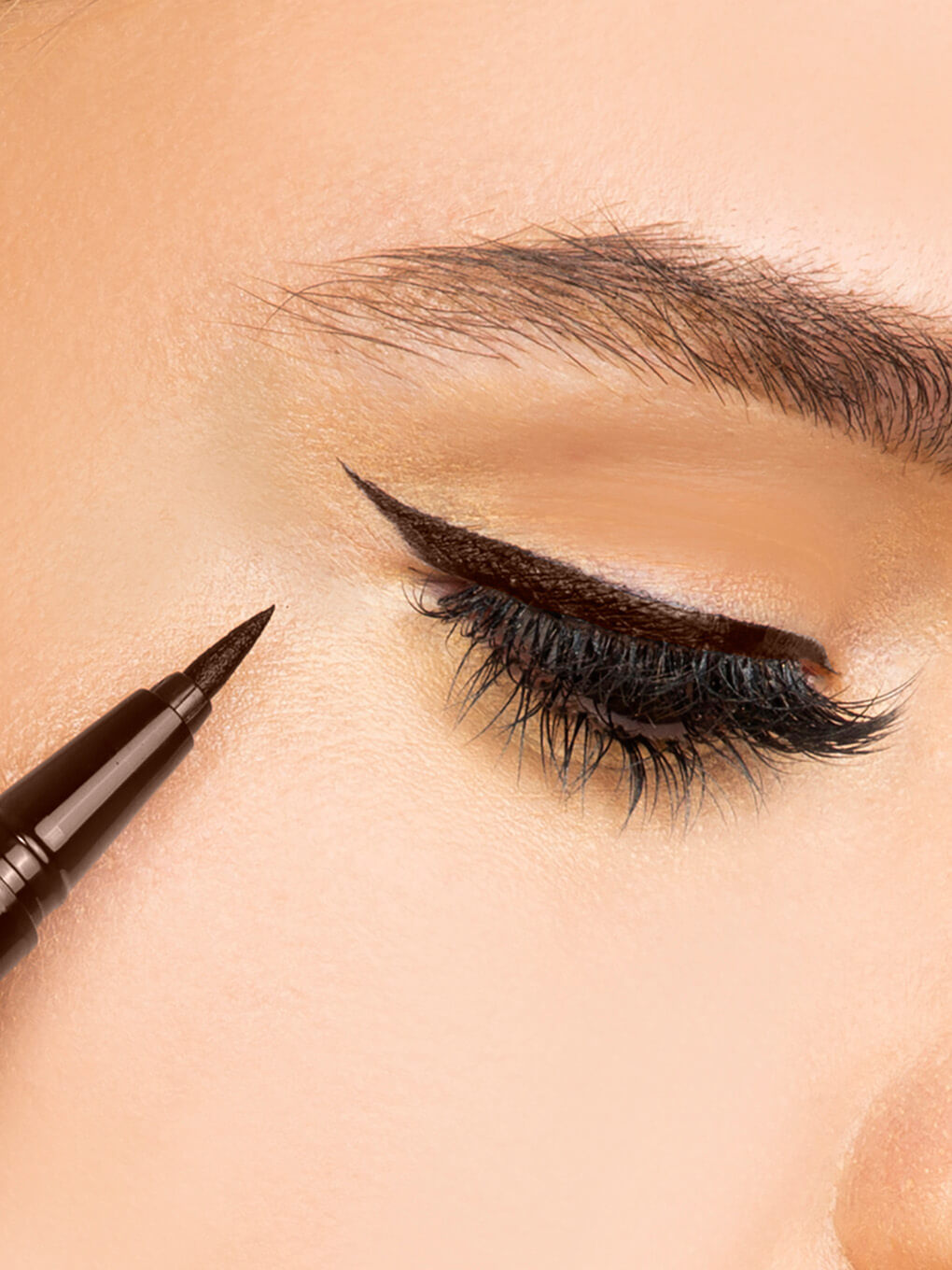 Chocolate -- close up of model eye with brown liquid mascara on top lid