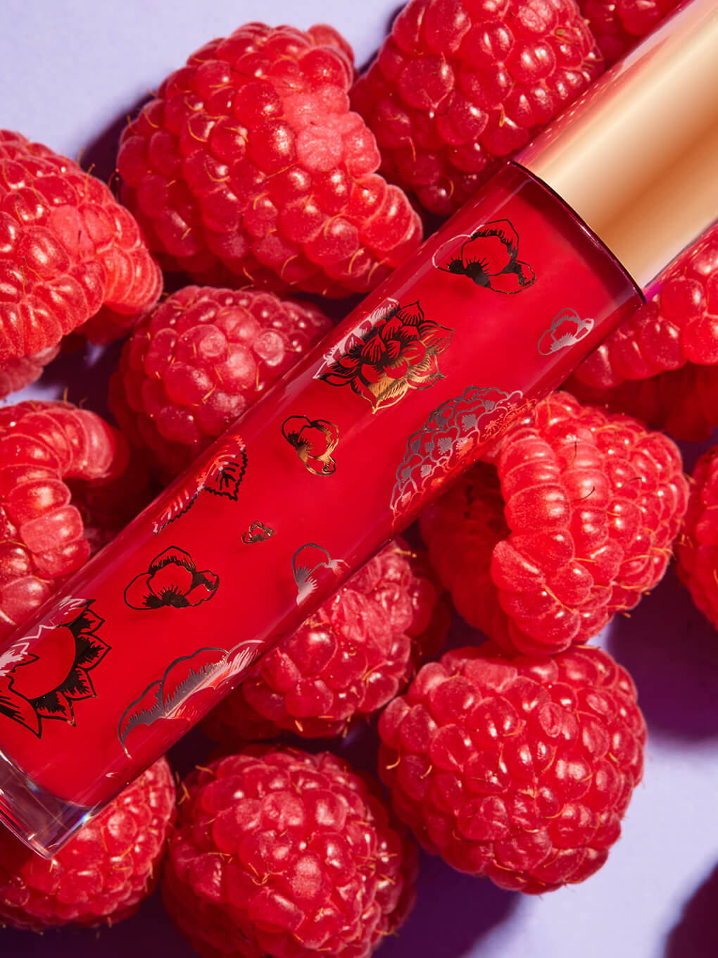 raspberry -- fruity ph gloss lying on a bed of raspberries