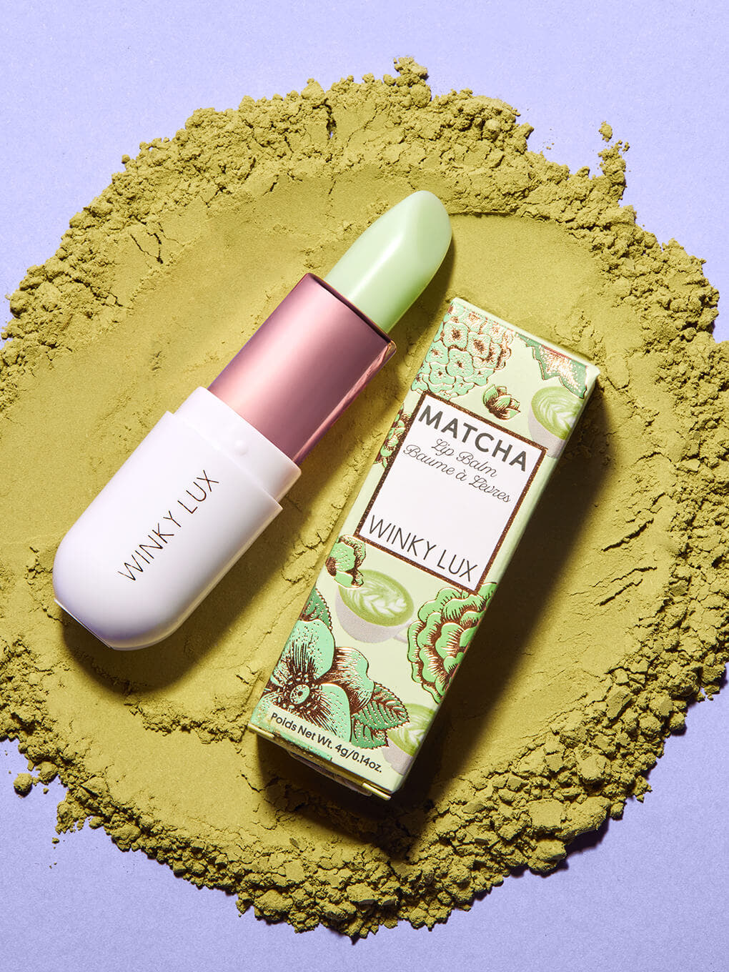 clear -- matcha lip balm and box laying down in matcha on purple backgrround