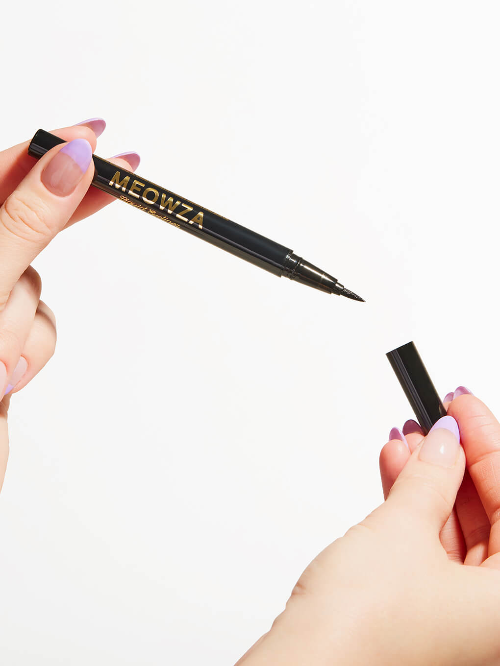 close up of model's hands holding meowza liquid eyeliner on white background