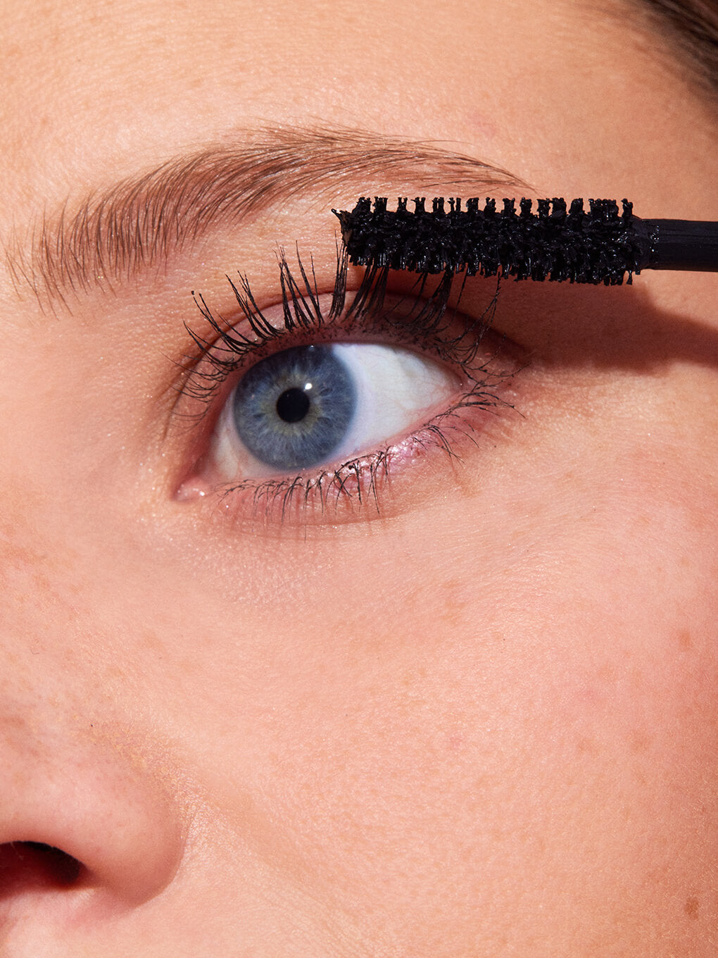 close up of blonde model applying so extra volumizing mascara