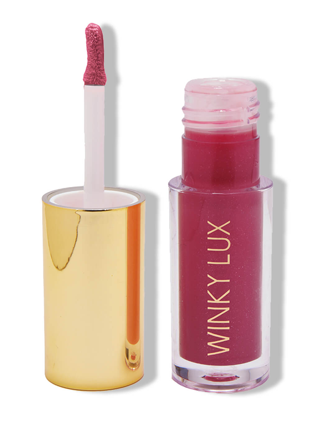 Berry -- tinted lip oil in berry pink on white background next to cap