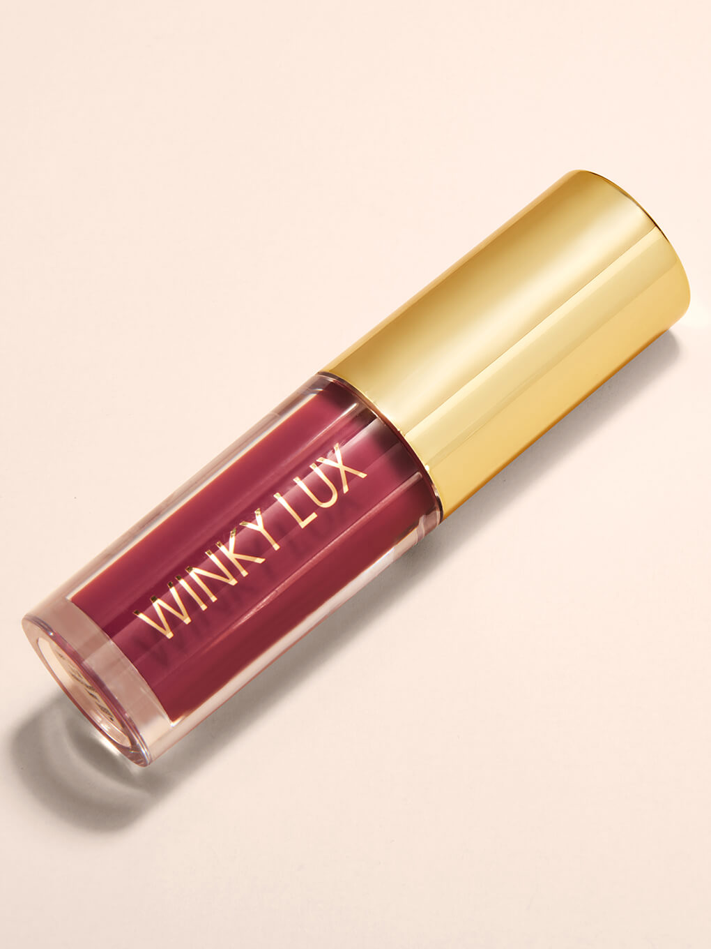 Berry -- flat lay of berry pink tinted lip oil with cap on