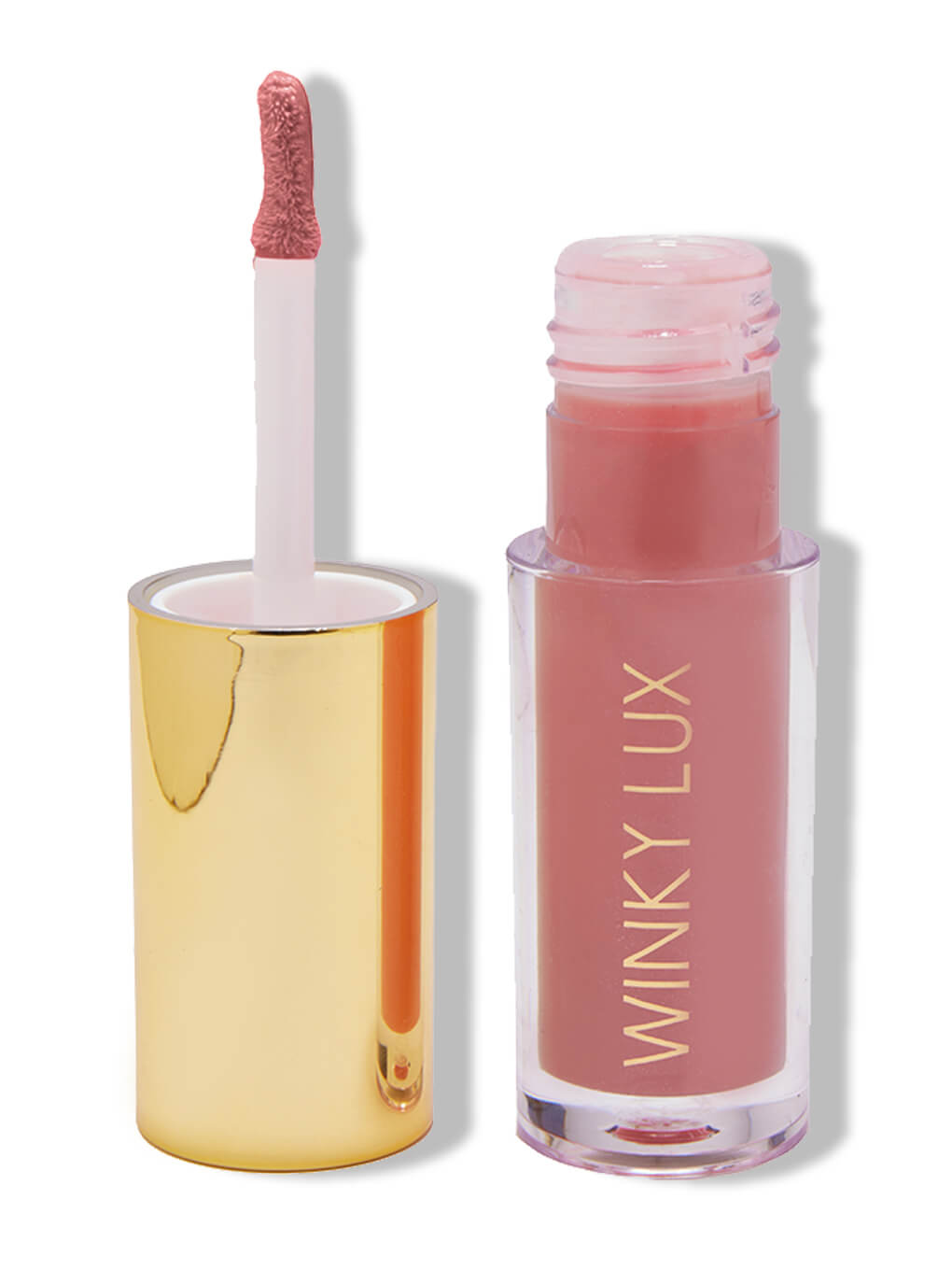 Muse -- tinted lip oil in sheer pink on white background next to cap