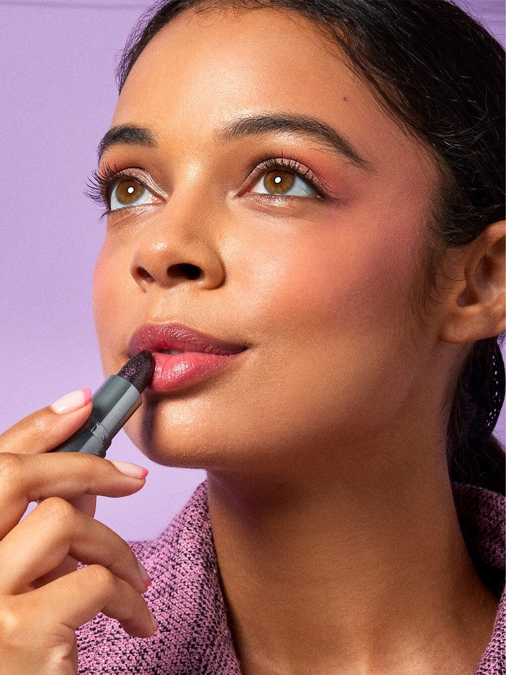 close up of brunette model applying aurora ph lip balm to lips