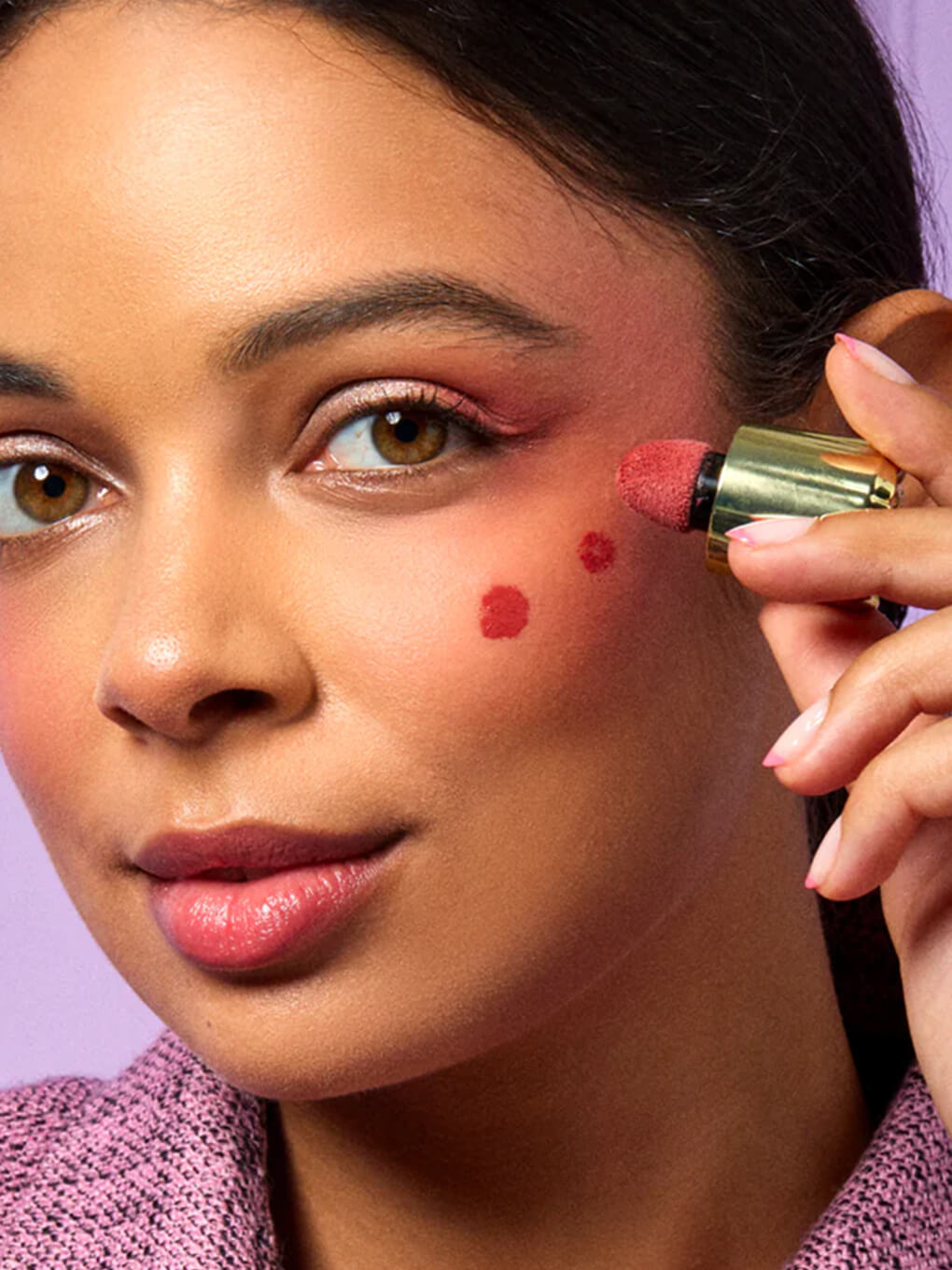 close up of brunette model applying cheeky rose liquid blush to cheek bone