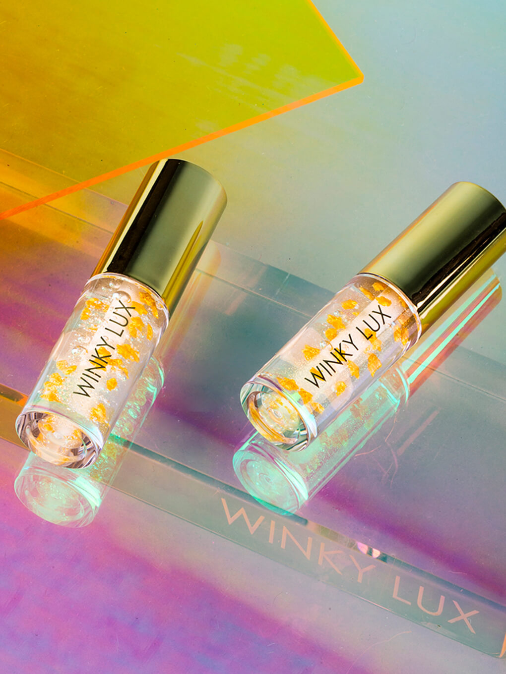 two in the stars nourishing lip oils on metallic background flat lay