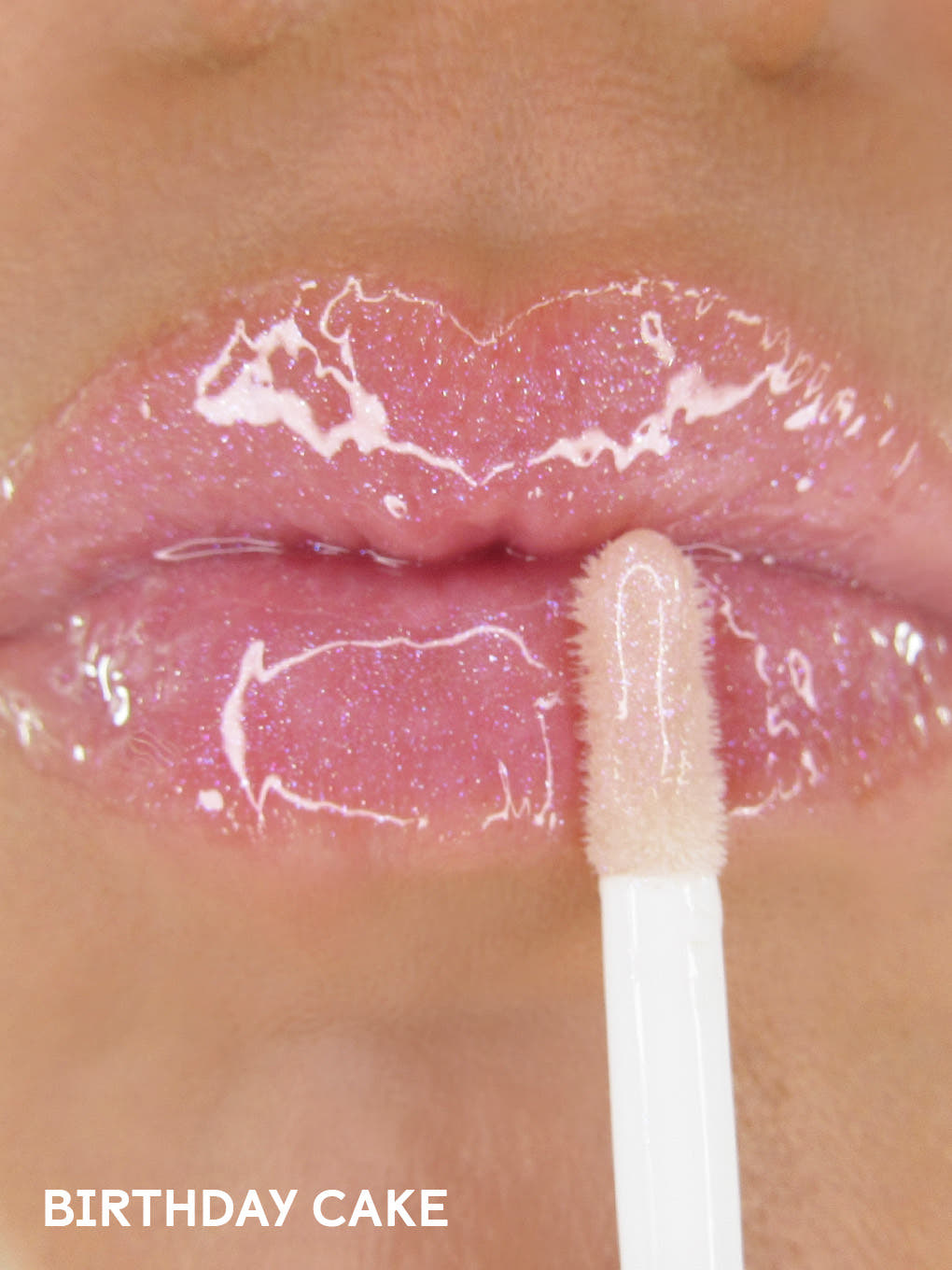 birthday cake shimmer -- close up of shimmer pink lip oil applied to lips