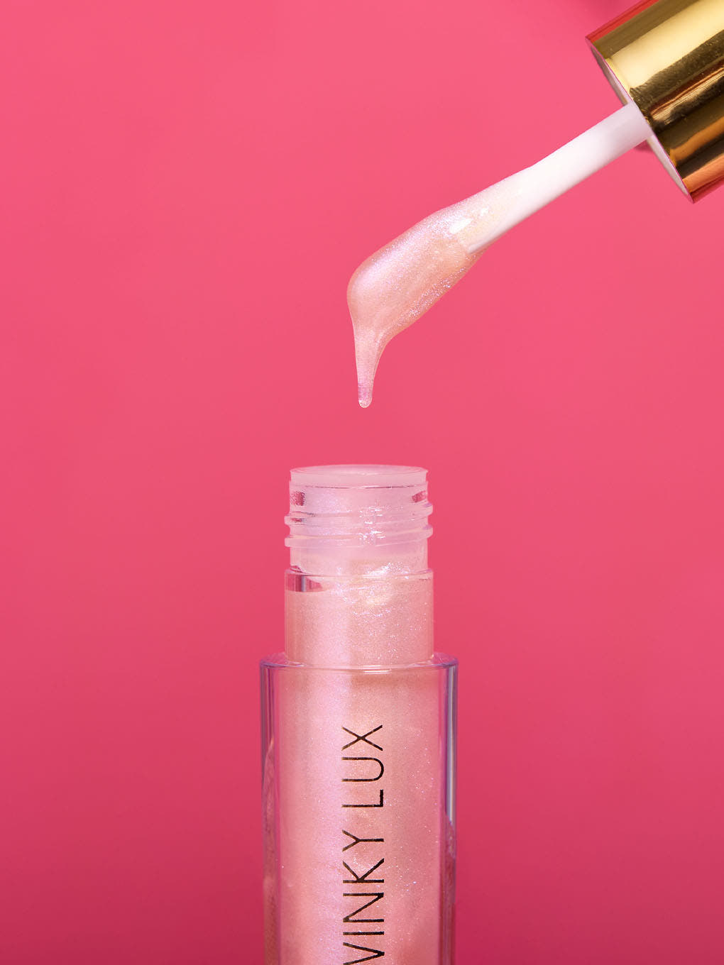 birthday cake shimmer -- stylized image of applicator coming out of bottle of shimmer pink lip oil