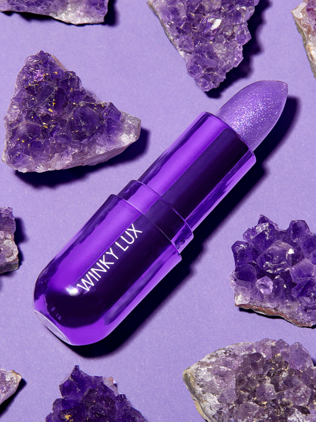 amethyst ph color changing lip balm flat lay with amethyst stones purple background