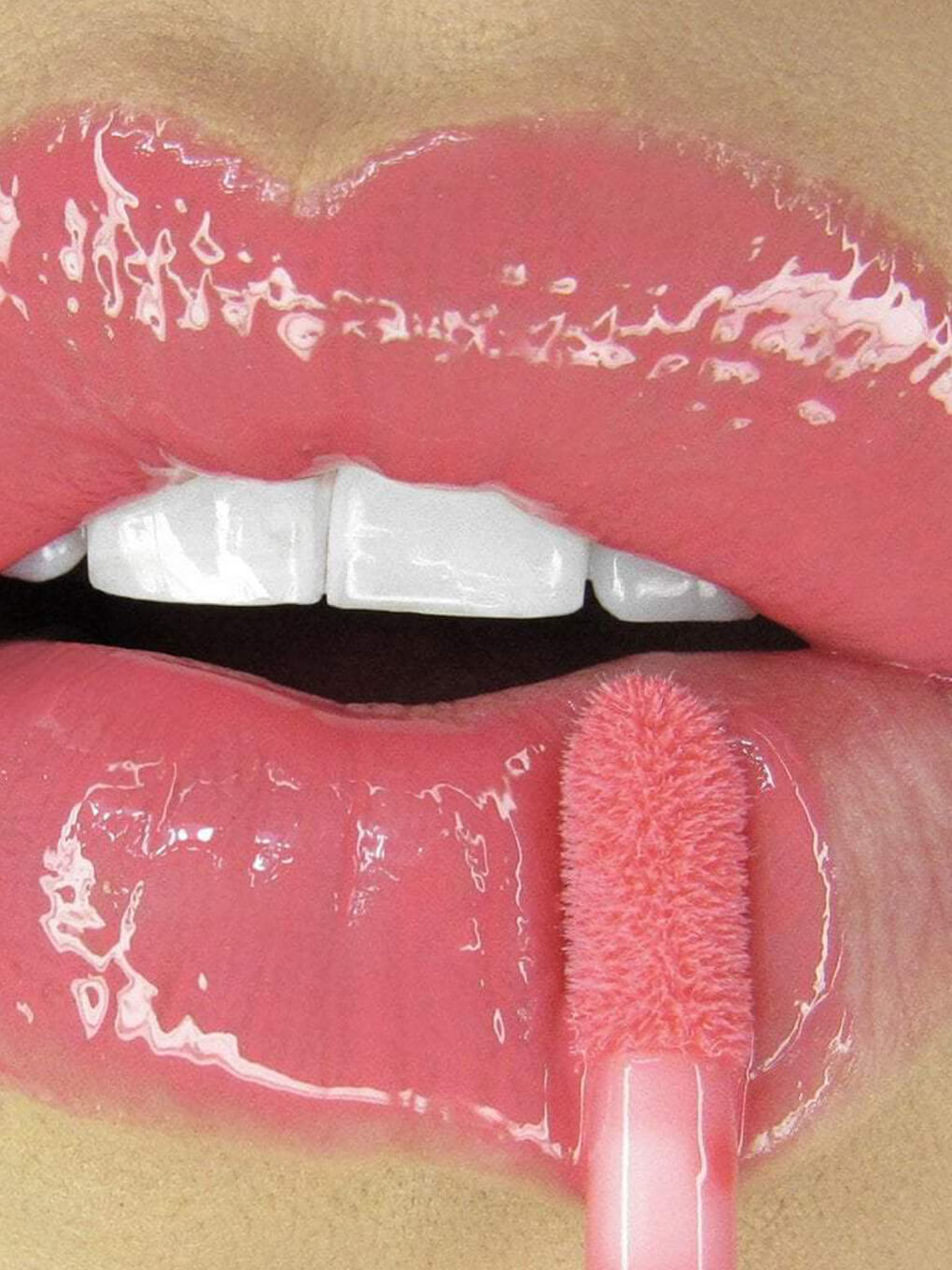 Juicy -- close up of model applying glossy boss lip gloss to lips